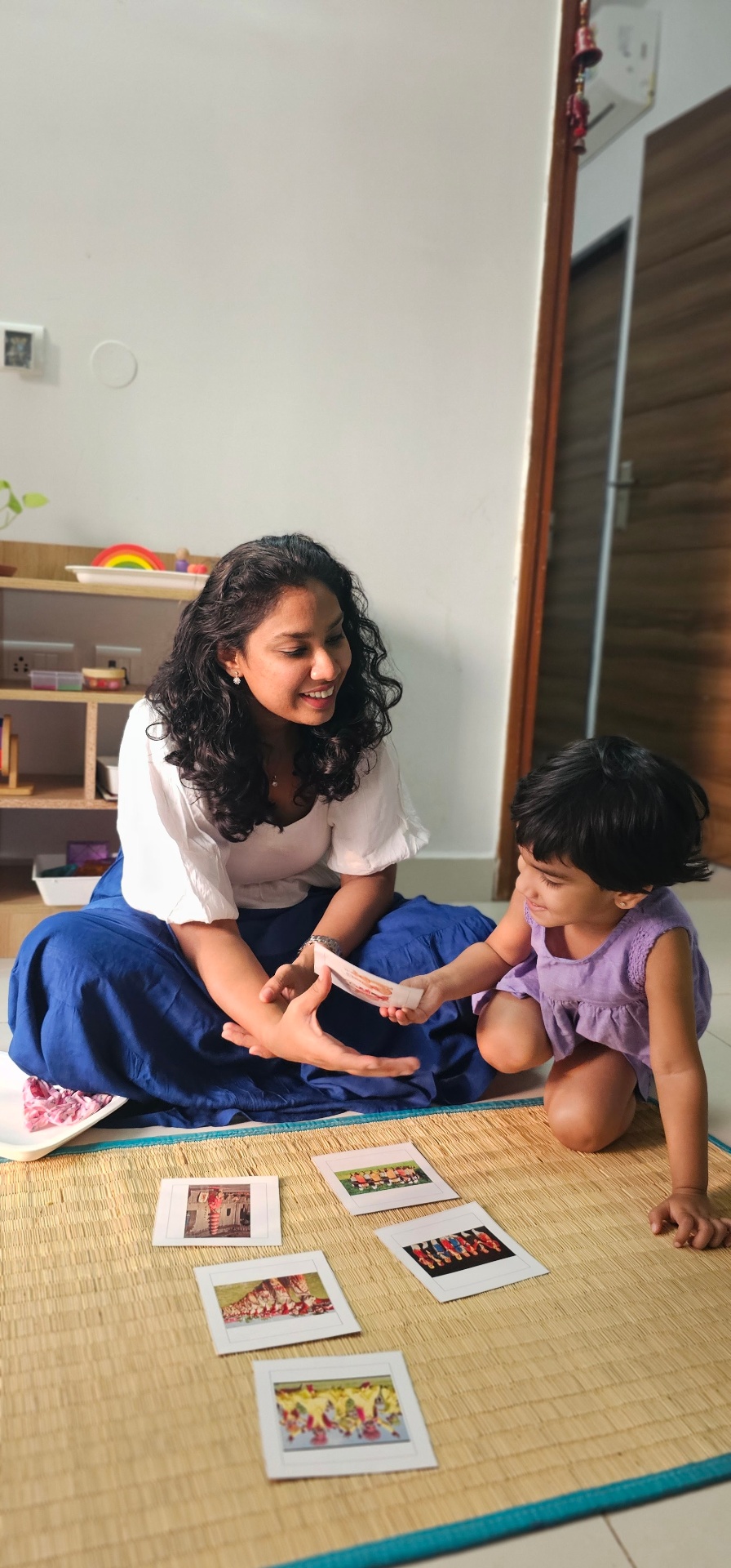Host sitting with her daughter, exploring Montessori cards together